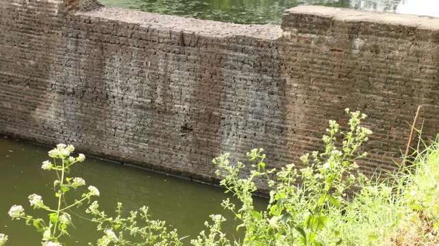 Ancient brick water gate and irrigation canal system in Sukhothai Historical Park, UNESCO World Heritage site, Thailand.