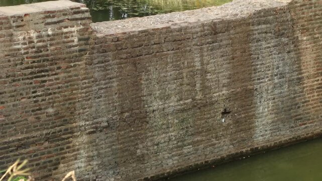 Ancient brick water gate and irrigation canal system in Sukhothai Historical Park, UNESCO World Heritage site, Thailand.