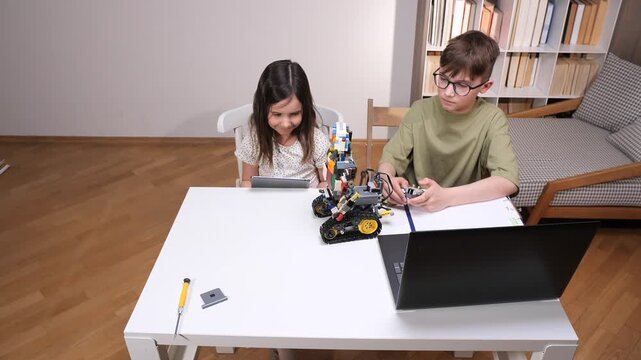Two young kids building a modular robot with colorful blocks, using a digital tablet for instructions and a laptop for programming, fostering stem education and innovation