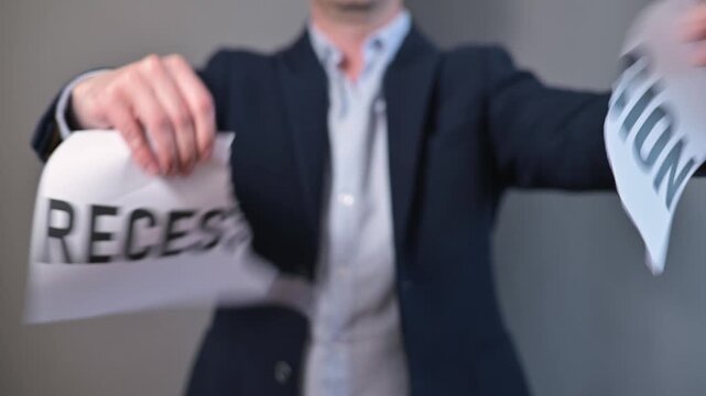 A person removes the word recession from a piece of paper, showing the transformation to the word recess