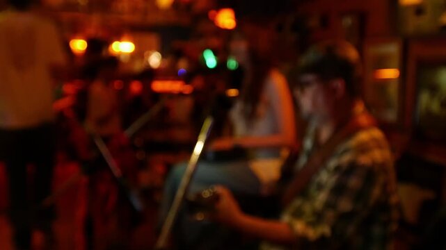 Blurred defocused live music jazz band performance inside cozy vintage bar with warm golden red bokeh ambiance nightlife