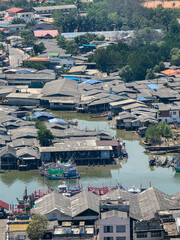 Fototapeta premium Aerial view captures tranquil rustic fishing village community featuring wooden house structure on stilt over water reflecting resilient lifestyle of traditional waterfront settlement