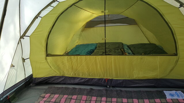 Interior view of large camping tent with travel equipment