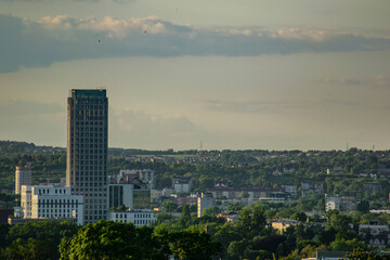 Fototapeta premium Modern skyscraper rising above Krakow cityscape during golden hour