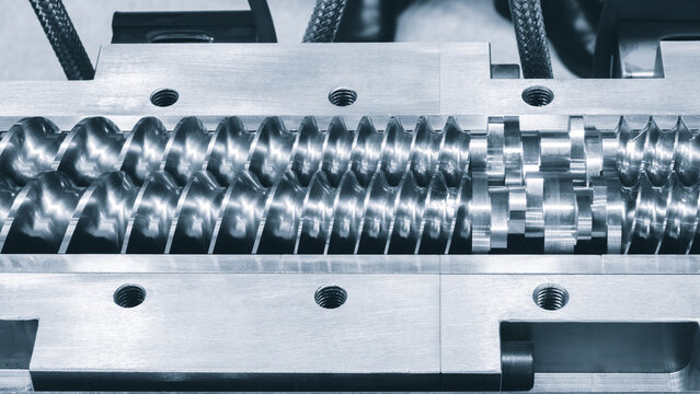 Spiral screw shaft for feeding granules into production machine for manufacture products from pvc plastic extrusion technology, industrial concept background