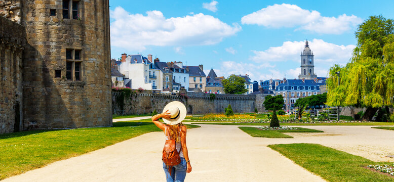 Rear view of woman with straw hat walking in vannes castle gardens brittany, tour tourism, travel destination in France
