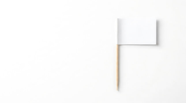 Small blank white paper flag on a wooden toothpick isolated on a white background with copy space for text.