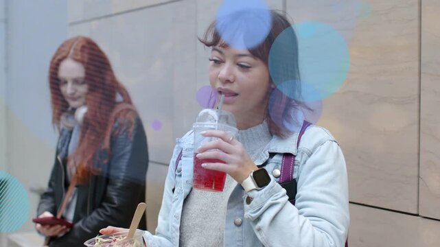 Lead woman lifting cup and sipping to refresh, causing animated circles growing across scene, tech