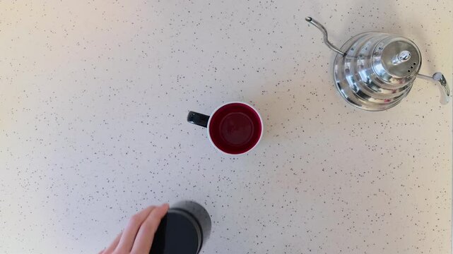 Unrecognizable Man in Domestic Robe Making Instant Coffee Top Down View Putting Mug Jar Spoon and Sugar on White Table then Pouring Hot Water from Metal Kettle into Cup with Rising Steam Concept