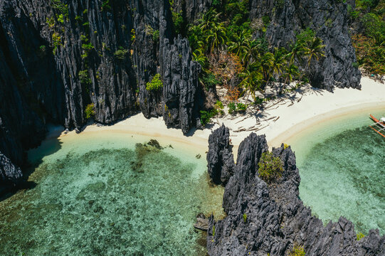 Small lagoon in El nido. People walking on the white sand, with tropical jungle in the background. Concept about traveling and nature