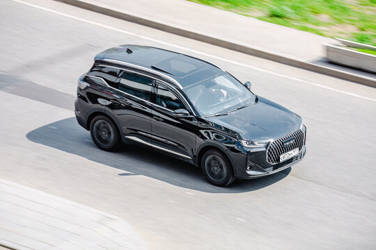 Tenet T7 rides on the road. Black compact crossover SUV on the city street in motion.