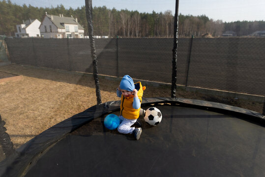 Toddler boy playing with balls on trampoline
