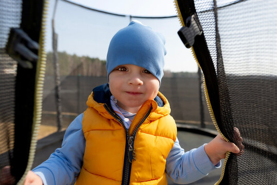 Young boy smiling inside trampoline enclosure