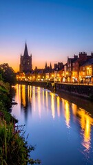 Fototapeta premium Long exposure shot of a serene river reflecting illuminated buildings under a twilight sky. A church steeple rises over the town