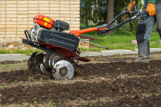 A powerful gasoline-powered tiller or walk-behind tractor is used for spring soil preparation. The images show the mechanical process of loosening the earth, with focus on the metal blades (tines)