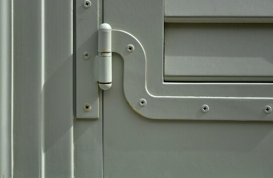 Traditional wooden window shutter with a matching metal hinge in Nafplio, Greece.