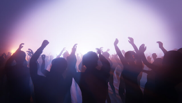 Energetic crowd enjoying a music concert with hands in the air and bright stage lights