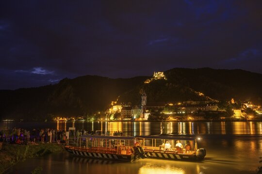 People and bicycle ferry from Rossatz and behind D&uuml;rnstein in front of the fireworks for the solstice, Rossatz-Arnsdorf, Lower Austria, Austria