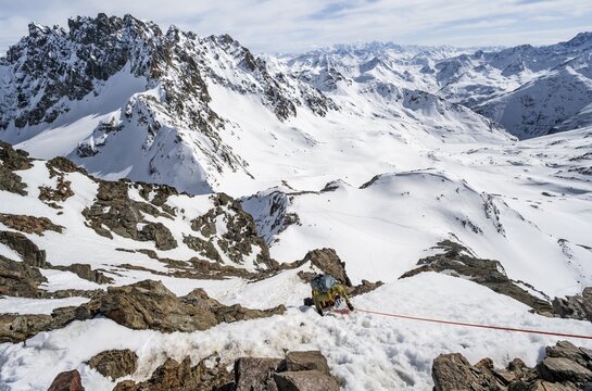 Mountaineer climbing up a steep snow slope, secured by a rope, ascent to the summit of Piz Grialetsch in winter, view of mountain panorama with Piz Vadret with snow, Grisons Haute Route, Albula Alps, Rhaetian Alps, Grisons, Switzerland