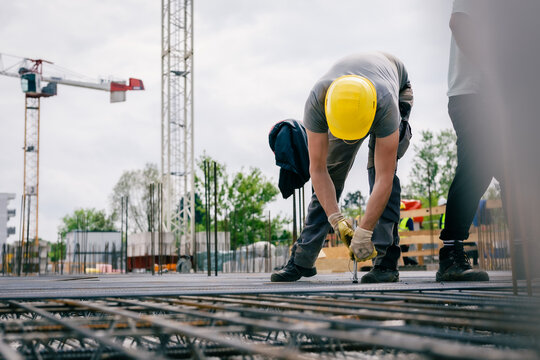 Eisenflechter mit Zange auf Baustelle 