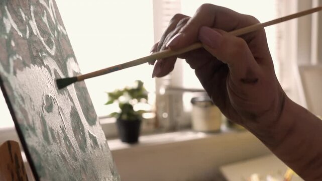 art studio, painter using watercolor paints to create artwork on canvas.