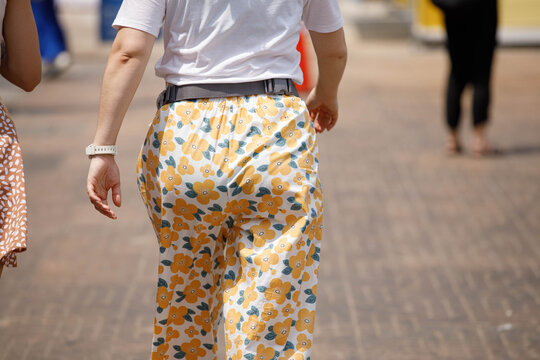 Female hips walking, unposed movement, natural candid motion, rear view.