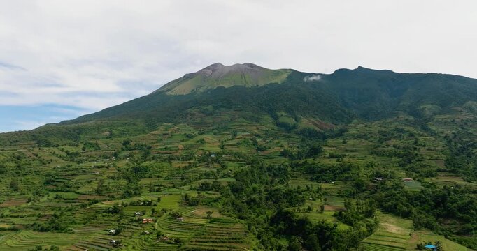 Farmland against a background of mountains and blue sky view from above. Canlaon volcano. Negros, Philippines