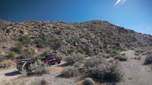 Aerial views show a teardrop camper and SUV traveling through Anza Borego Desert and Prune Canyon, showcasing the rugged landscape.