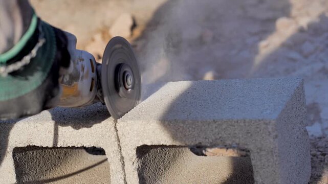 Close-up of a cutting machine splitting a construction brick of a house