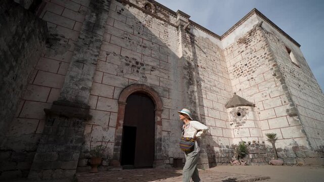 Mature woman enjoys her time at Mission Church in San Ignacio Baja California while sightseeing in this historic location.