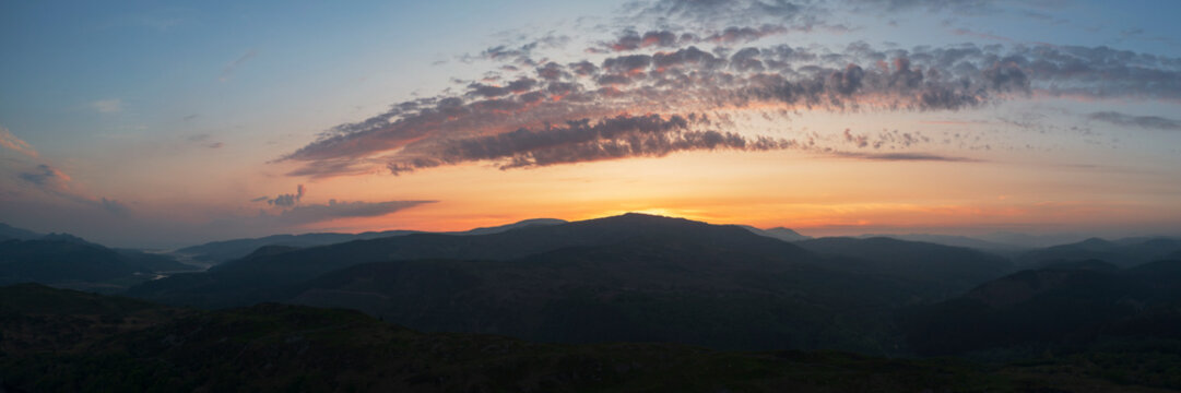 Sunset over the Mawddach Estuary, silhouettes of the hills, and view to the sea.