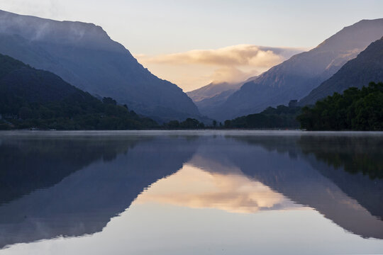 Llyn Padarm, Llanberis, a view across the flat calm waters of the lake with reflections of the mountains
