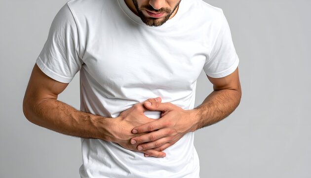 Man in pain clutching his stomach, white t-shirt, neutral background