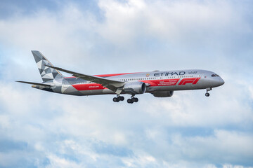 Fototapeta premium PRAGUE, CZECH REPUBLIC – MAY 06, 2026: Etihad Airways Boeing 787-9 Dreamliner Abu Dhabi Grand Prix Livery REG: A6-BLV in Flight Against Cloudy Sky