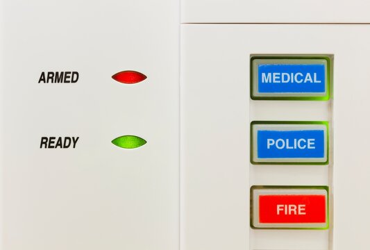 Closeup of alarm keypad showing the system is armed along with buttons for medical, police, and fire emergencies.