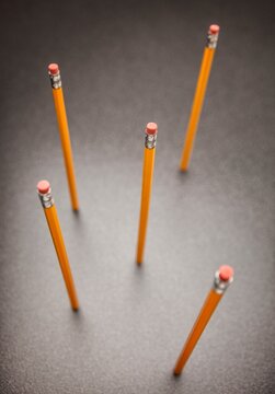 Unsharpened yellow no.2 pencils standing up on desk, view from above