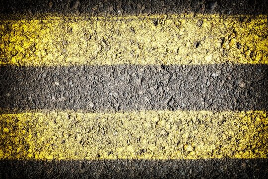 Extreme closeup of double yellow lines painted on the roadway