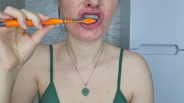 Detail of a woman brushing upper teeth, professional dental hygiene habits and stomatology care at home