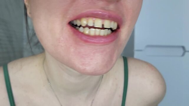 Woman looking in the mirror while brushing teeth, morning bathroom routine and dental hygiene focus amalgam filling