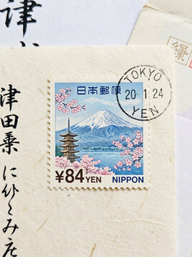 Classic Japan stamp with Mount Fuji, sakura flowers, and a postmark.