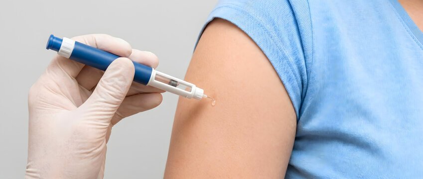 Healthcare professional wearing gloves administering insulin injection with a pen device