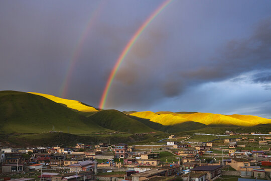 View from the Dege Zhuqing Mansion Hotel at Sunset, a double rainbow in the sky above the mountains.