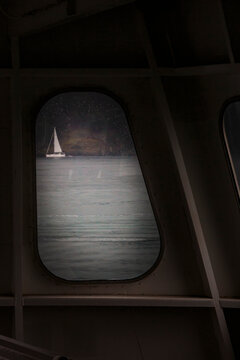 Sailing boat seen through a porthole from a ferry.