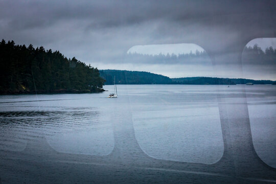 A reflection on a ferry window and view of the San Juan Islands ferry