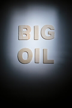 Big Oil sign, lettering on a plain surface, shadows, studio shot