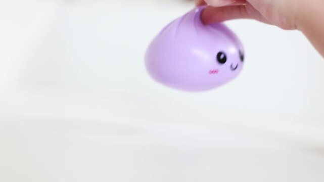 Hand holding purple dumpling stress squishy toy