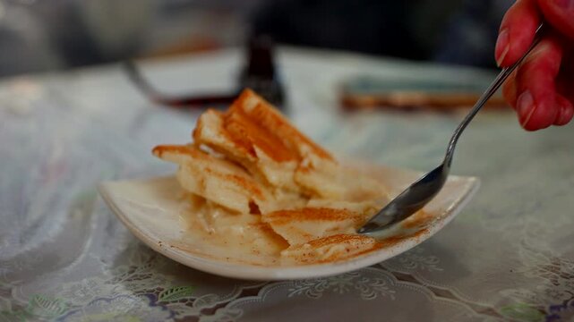 Handheld close-up of Queso helado, a traditional cinnamon milk ice cream being eaten with a spoon. This authentic Peruvian dessert is a famous culinary specialty in Arequipa, Peru