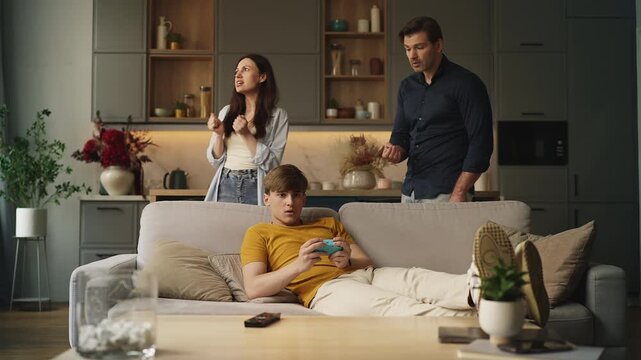 Displeased parents reprimanding their rebellious teen son for excessive gaming
