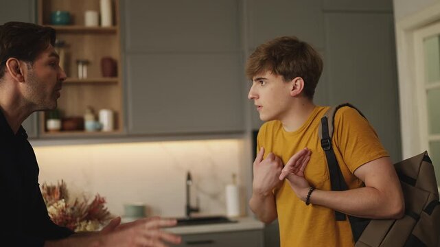 Annoyed parents scolding teen son as boy prepares to leave home, family conflict