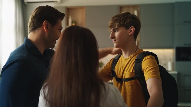 Teenage son hugging his parents before leaving for college, family support